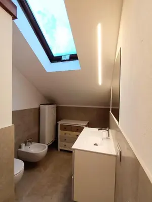 a bathroom with a sink and a skylight at La Casa Duron in Campitello di Fassa
