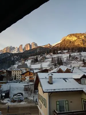 a view of a town with mountains in the background at La Casa Duron in Campitello di Fassa