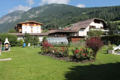 a house with a yard with flowers in front of it at Villa Alessandra in Colle Isarco
