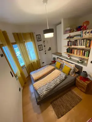 a living room with a couch and a book shelf at Villa Alessandra in Colle Isarco