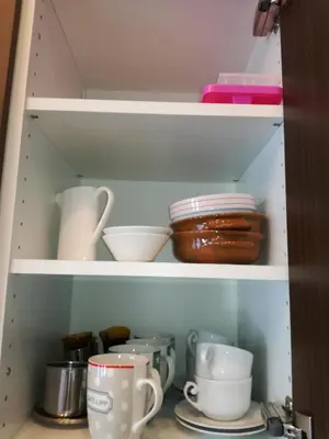 a cupboard filled with dishes and other kitchen items at Villa Alessandra in Colle Isarco