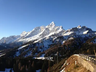 a snow covered mountain with a road in the foreground at Casa Alfredino in Rocca Pietore