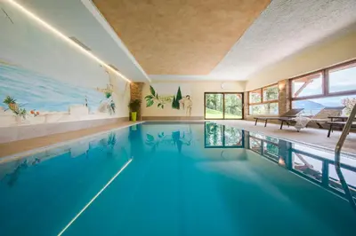 a swimming pool in a house with a painting on the wall at Prünsterhof Schenna in Schenna