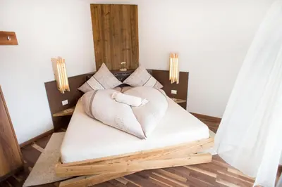 a bed with a heart shaped pillow on it at Prünsterhof Schenna in Schenna