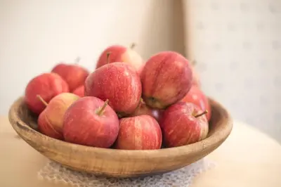 a wooden bowl of apples sitting on a table at Prünsterhof Schenna in Schenna