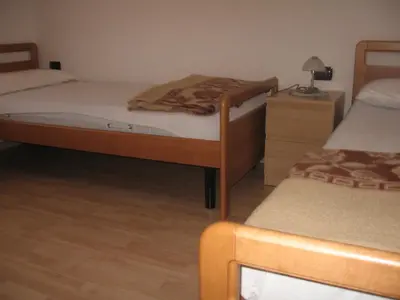 a bedroom with two twin beds and a night stand at Casa Franca in Cavalese