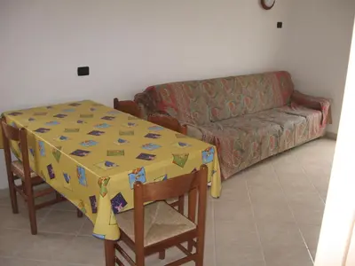 a living room with a table and a couch at Casa Franca in Cavalese
