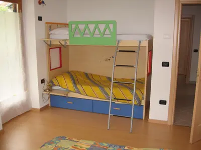 a bunk bed with a ladder in a room at Casa Franca in Cavalese