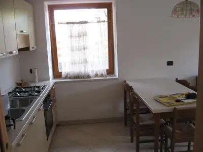 a kitchen with a table and a window and a table and chairs at Casa Franca in Cavalese