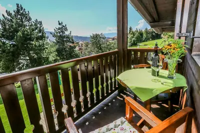 a balcony with a table with wine glasses at Alps Residence in Nova Ponente