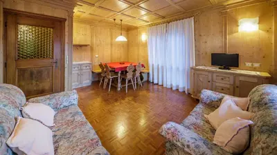 a living room with a couch and a table at Villa Chiappuzza - Stayincortina in San Vito di Cadore