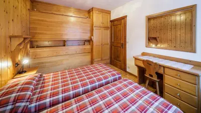 a bedroom with a bed and a desk at Villa Chiappuzza - Stayincortina in San Vito di Cadore