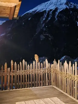 a wooden fence with a mountain in the background at Tratterhof Apartments in Vallarga