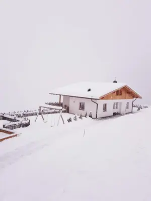 a building in the snow with a playground at Tratterhof Apartments in Vallarga