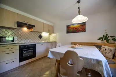 a kitchen with a table with a white table cloth at Schoenau Bio & SPA Family Apartments in San Pietro in Gardena