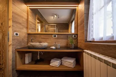 a bathroom with a sink and a mirror at Schoenau Bio & SPA Family Apartments in San Pietro in Gardena