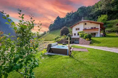 a house on a hill with a pool in the yard at Schoenau Bio & SPA Family Apartments in San Pietro in Gardena