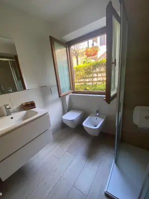 a bathroom with a sink and a toilet and a window at Almida in Castello di Fiemme