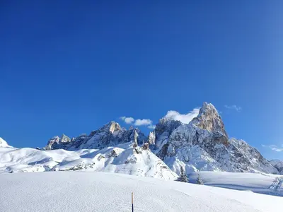 a snow covered mountain range with a blue sky at Almida in Castello di Fiemme