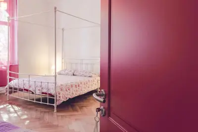 a bedroom with a bed and a red door at Bolzano Rooms in Bolzano