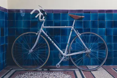 a bike parked in a bathroom with blue tiles at Bolzano Rooms in Bolzano