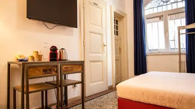 a bedroom with a bed and a television on a wall at Bolzano Rooms in Bolzano