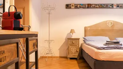 a bedroom with a bed with a suitcase and a lamp at Bolzano Rooms in Bolzano