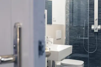 a bathroom with a sink and a toilet and a shower at Bolzano Rooms in Bolzano