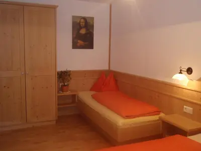 a bedroom with a bed with an orange blanket at Apperlehof in Villabassa