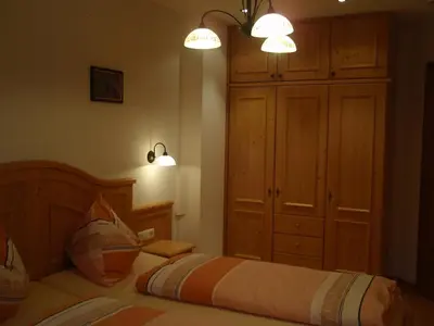 a bedroom with a bed with two lights and a cabinet at Apperlehof in Villabassa