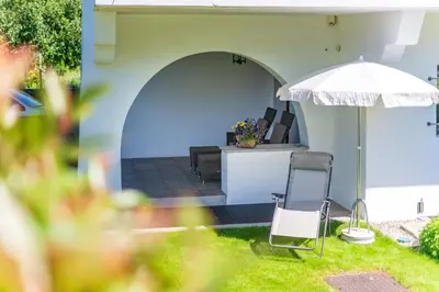 a patio with an umbrella and chairs and a table at Haus Oberhofer in Cornaiano