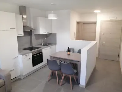 a flat screen tv sitting on top of a white cabinet at Apartments Max in Mendola
