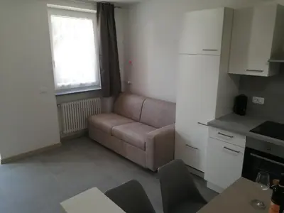 a living room with a couch and a painting on the wall at Apartments Max in Mendola