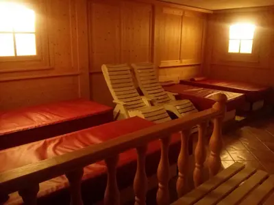 a room with two beds and two chairs at Albergo Arnica in Canazei
