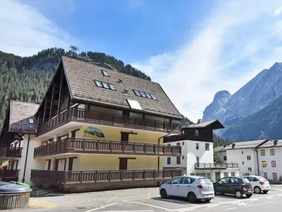 a large building with cars parked in a parking lot at Studio Apt 14 by Interhome in Alba di Canazei