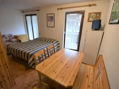a bedroom with a bed and a table and a television at Studio Apt 8 by Interhome in Alba di Canazei