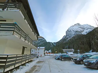 a building with cars parked outside in the snow at Studio Apt 8 by Interhome in Alba di Canazei