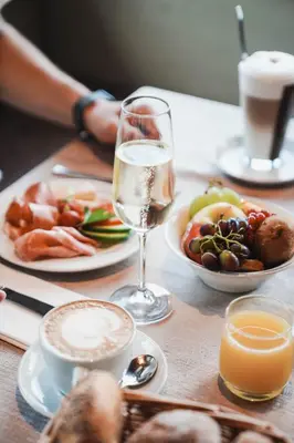 a table with a plate of food and a glass of wine at Hotel Mitlechnerhof in Schenna