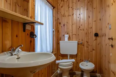 a bathroom with a white sink and a mirror at Cèsa Silvano in Rocca Pietore