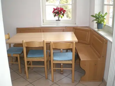 a wooden table and chairs in a kitchen with a window at San Cristoforo in Canazei