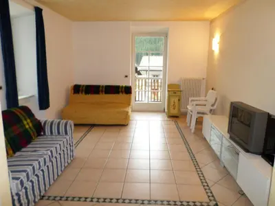 a living room with a couch and a tv at San Cristoforo in Canazei