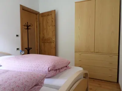 a bedroom with a pink bed and a dresser at San Cristoforo in Canazei