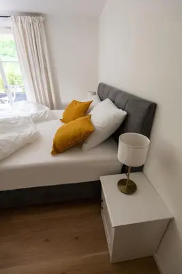 a bedroom with a bed with yellow pillows and a window at Huberhof Meran in Merano