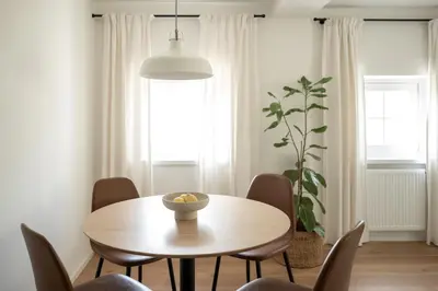 a dining room with a table and chairs and a plant at Huberhof Meran in Merano