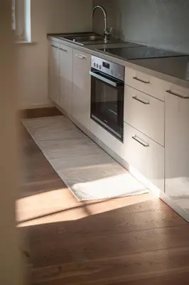 a kitchen with white cabinets and a stove top oven at Huberhof Meran in Merano