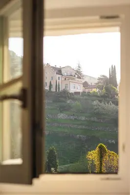 a window with a view of a green field at Huberhof Meran in Merano
