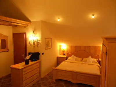a bedroom with a large bed with white pillows at Hotel Relais Grünwald in Cavalese