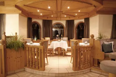 a restaurant with a table and chairs in a room at Hotel Enzian in Villa Ottone