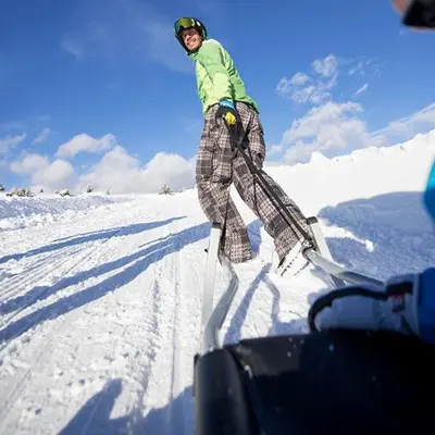 a person standing on skis in the snow at Hotel Enzian in Villa Ottone