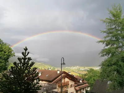 a rainbow in the sky over a city at Appartamento Bellavista in Cavalese